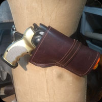 Holster for a cosplay gun.  Mounts at the small of teh back on a belt.  Simple brown with etched detailing and hidden hardware.