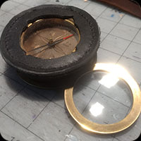 Cover for a marching compass with slide out magifying loup.
